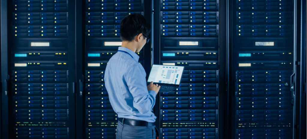 IT Engineer Standing Beside Open Server Rack Cabinets