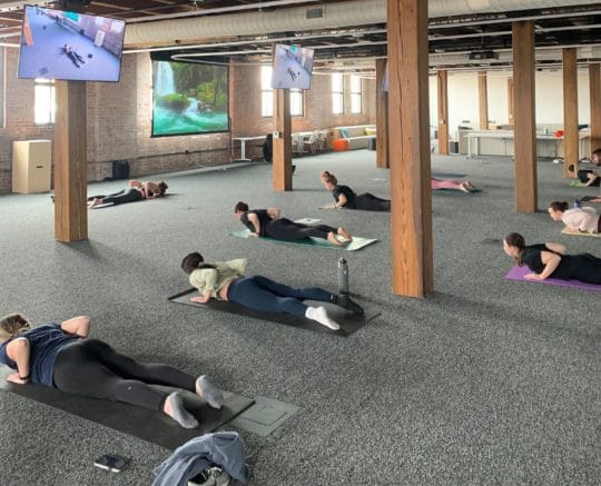 Roar members performing yoga with an instructor at the Omaha hub. 