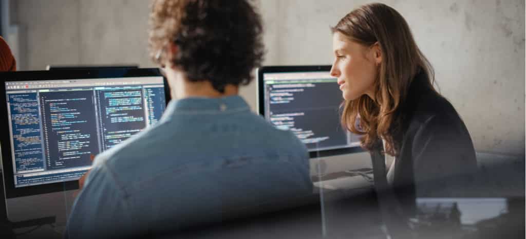 A man and woman looking at code