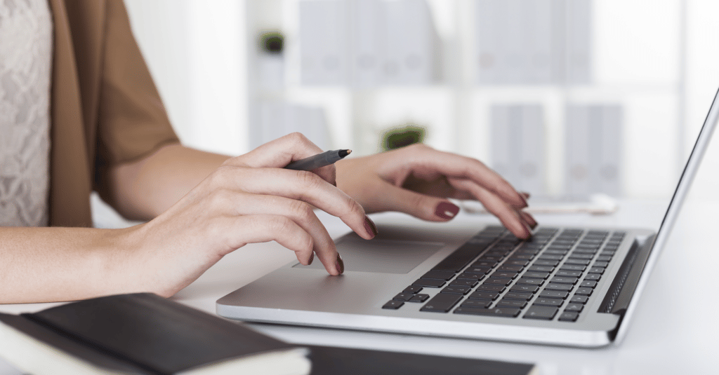 a woman types on a laptop