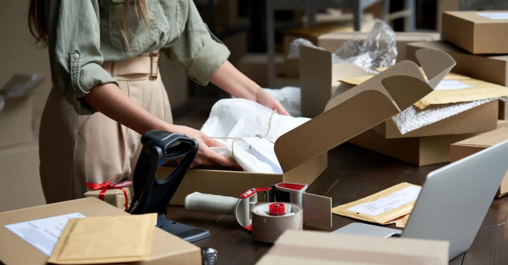 a woman packages products from her online store for shipping