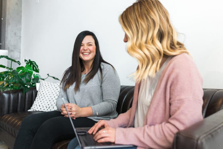 two women share a laugh as they collaborate on a new project