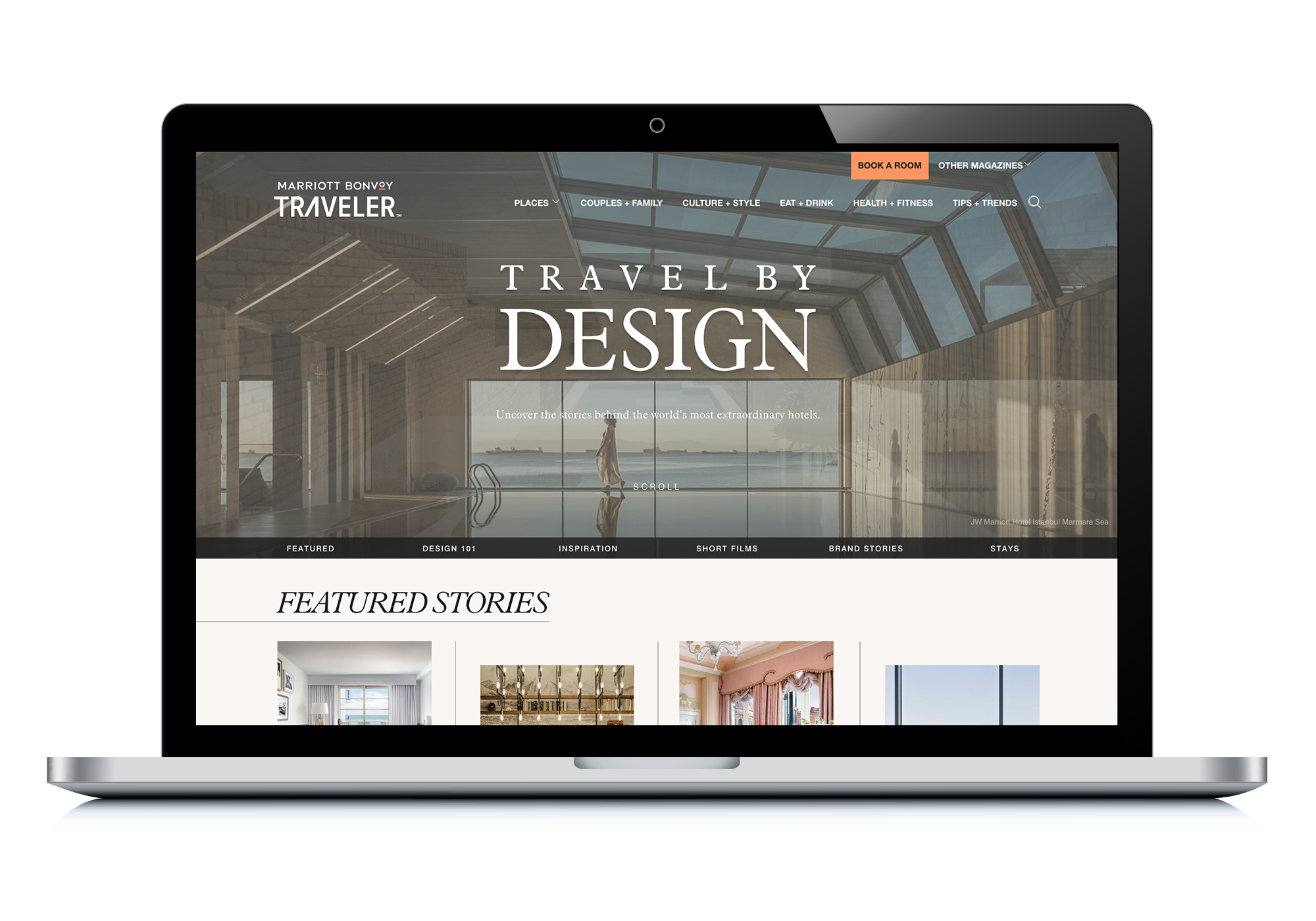 the Travel By Design home page displayed on a mac laptop